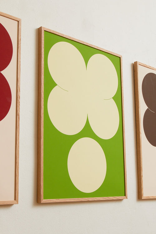 Art print featuring playful, bold typography of the letters X and O, hugs and kisses, in yellow-green against a bright green background. Styled in a minimalist interior.