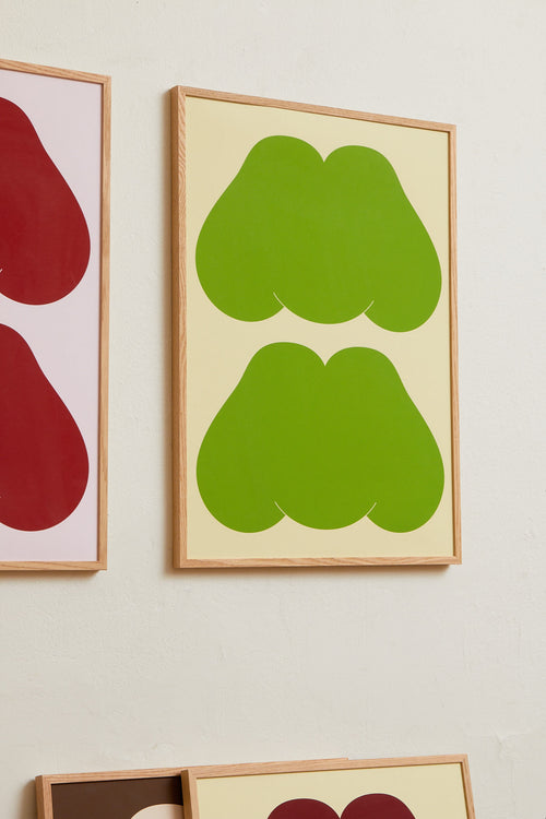 Art print featuring playful, bold typography of the text “MM”, the sound of enjoyment, in green against a yellow-green background. Styled in a minimalist interior.