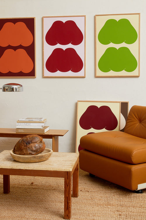 Art print featuring playful, bold typography of the text “MM”, the sound of enjoyment, in green against a yellow-green background. Styled in a minimalist interior.