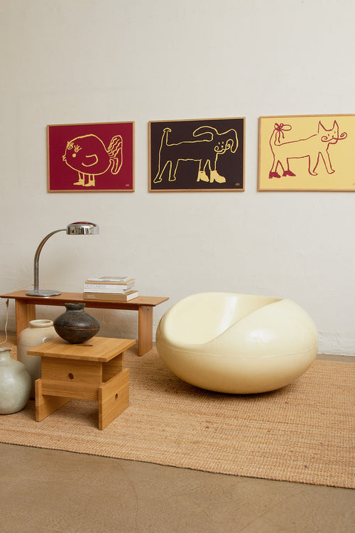 Interior scene with yellow and red art prints displayed together on a wall