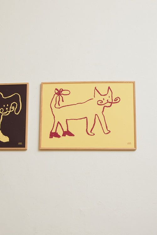 Side view of the framed yellow cat print displayed against a light wall