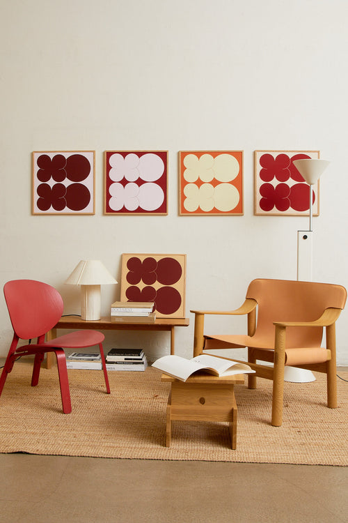 Square-format Art print featuring playful, bold typography of the letters X and O, hugs and kisses, in burgundy against a pink background. Styled in a minimalist interior.