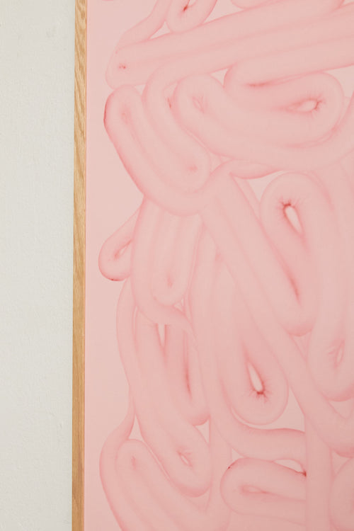 Art print with dense, rounded shapes in two shades of pink with a smooth, glossy feel. Styled in a minimalist interior.