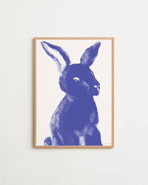 Framed artwork of a blue rabbit on a white wall