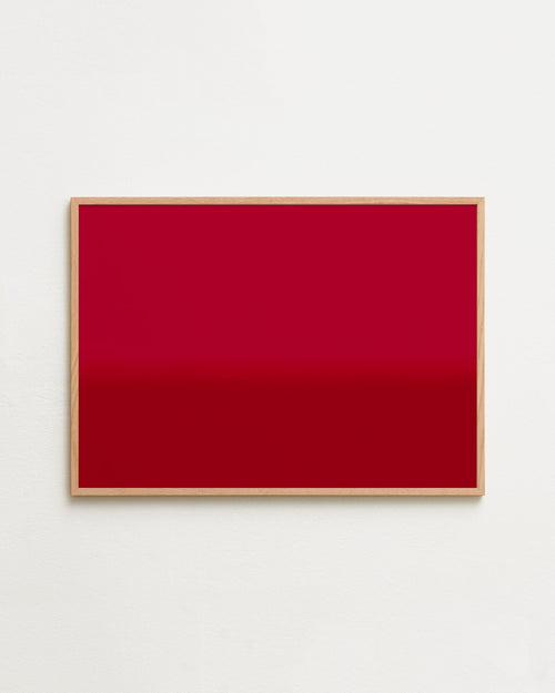 Framed red artwork on a white wall