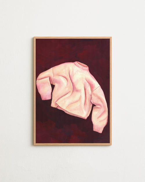 Framed artwork of a pink sweater on a dark red background