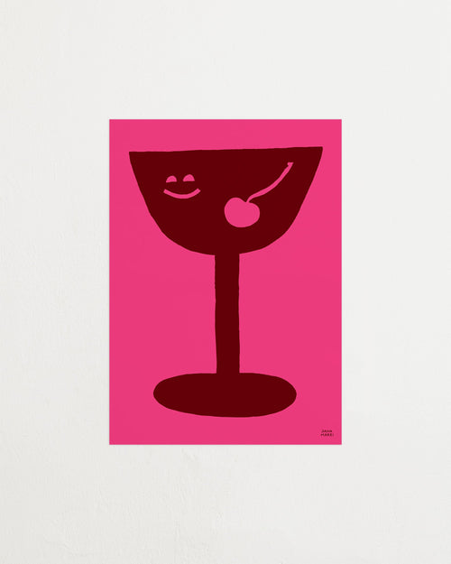Red cocktail glass with a cherry on a pink background