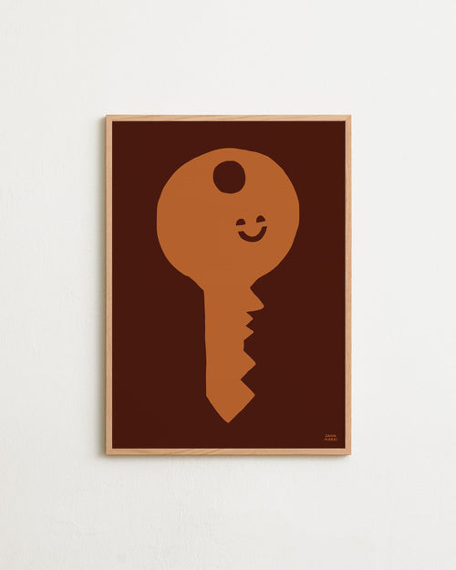 Framed artwork of a key-shaped face with a smile on a brown background