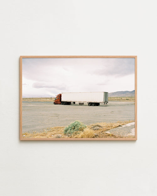 Framed photograph of a truck on a desert road with a wooden frame.