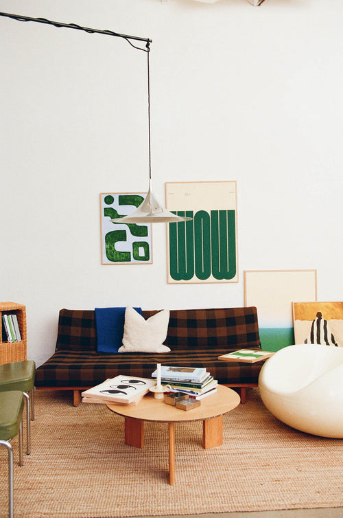 Modern living room with a plaid sofa, coffee table, and decorative pillows.